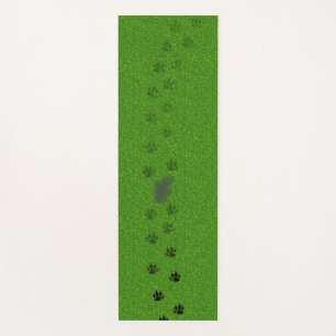 Groen gras met hondenpootafdrukken en een plasje yogamat