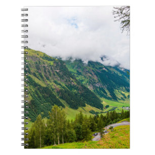Groene bergen bedekt met bos en groene gras notitieboek