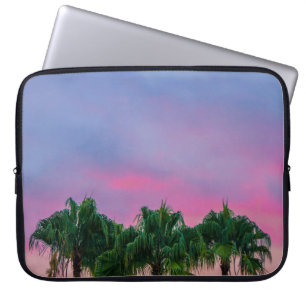 Groene bladeren onder blauwe hemel tijdens gouden laptop sleeve