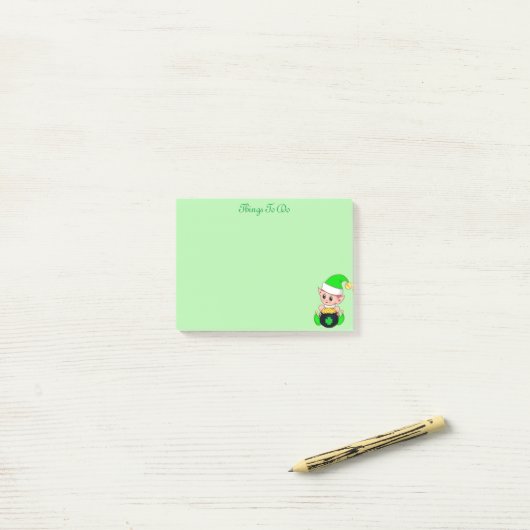 Groene elf en gouden munten op groen post-it® notes (Op bureau)