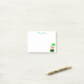 Groene elf en gouden munten op wit post-it® notes (Op bureau)