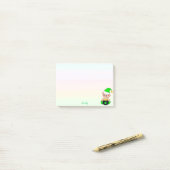 Groene elf & gouden munten op pastelkleuren post-it® notes (Op bureau)