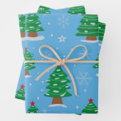 Groene kerstbomen met vallende sneeuw op blauw inpakpapier vel (In situ)