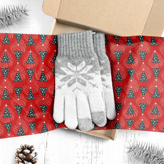 Groene kerstbomen op rode werveling tissuepapier