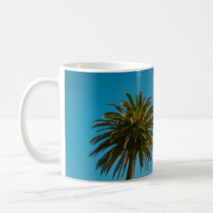 Groene palmboom onder blauwe hemel 's ochtends koffiemok