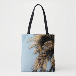 Groene palmboom onder blauwe hemel 's ochtends tote bag