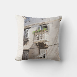 GROENE PLANT OP BROWN CONCRETE HOUSE BALCONY KUSSEN