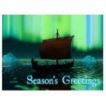 Groeten van het seizoen - Viking Ship Fotobeeldje Magneet<br><div class="desc">Een enigszins gestileerd afbeelding van een Viking-beugschip dat 's nachts onder de Noordelijke Lichten vaart,  daar een paar ijsbergen. De meeste bemanningen slapen. "Seizoensgroeten" staat in gloeiend blauw en wit.</div>