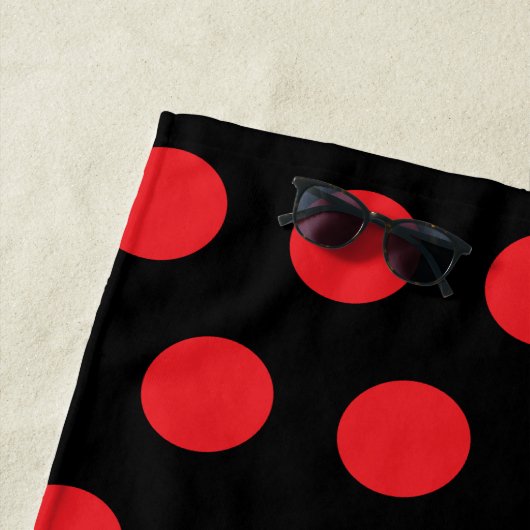 Grote rode stippen op zwart strandlaken (In situ)