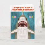 Grote witte haai Funny Jawsome Birthday Pun Humor Kaart<br><div class="desc">De grote witte haai op dit grappige wenskaart is zo aardig. Zie je? Het glimlacht en hoopt dat je een kaakachtige verjaardag hebt. Het bracht zelfs ballonnen mee en balanceert een kaars op zijn neus. Het ontwerp omvat een met de hand getrokken haai op een blauw/zee groene achtergrond met de...</div>