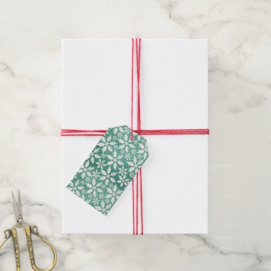 Grote witte sneeuwvlokken die vallen tegen een gro cadeaulabel (Met Touw)