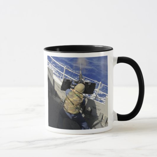 Gunners Mate die een pistool van 50 kaliber ontste Mok (Rechts)