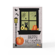 Halloween-venster met zwarte kat en pompoenen