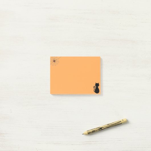 Halloweenspin en zwarte kat op sinaasappel post-it® notes (Op bureau)