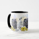 Hand die een grappige zwarte britse kat met bloeme mok (Voorkant links)