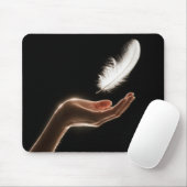 Hand die een witte veer loslaat muismat (Met muis)