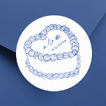Hand getrokken  taart blauw grillige bruiloft ronde sticker<br><div class="desc">Gepersonaliseerde taart bruiloft monogram Stickers. Deze aangepaste ronde trouwstickers zijn voorzien van een eenvoudige taartillustratie in stijl in het midden, geaccentueerd met elegante blauw-tinten en bekroond met de monogram-initialen van het paar en de trouwdatum voor een tijdloze en verfijnde touch. Het minimalistische ontwerp toont een mix van klassieke seriële en...</div>