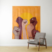 Handen met vuist opgevoed boven gele zon wandkleed (In situ)