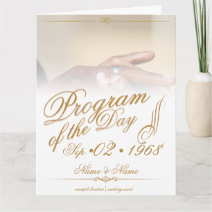 Handen van een gekleurd bruidspaar spelden op ring kaart