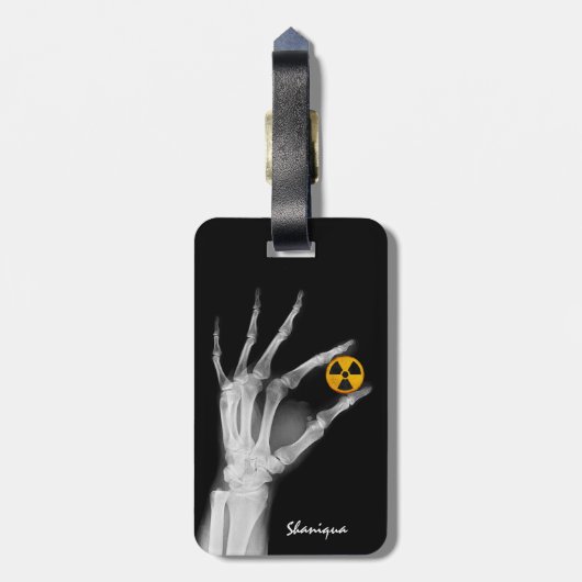Handje dat een radiatiesymbool vasthoudt bagagelabel (Achterkant verticaal)