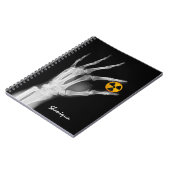 Handje dat een radiatiesymbool vasthoudt notitieboek (Linkerzijde)