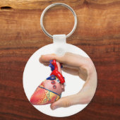 Handje houdt model menselijk hart vast tussen ving sleutelhanger (Voorkant)