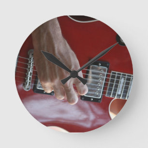 Handje met rode elektrische gitaar nabij pickup ronde klok