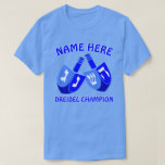 Hanukkah Dreidels in Blue Cute Dreidel Champion T-shirt<br><div class="desc">Voeg een naam toe aan dit grappige Dreidel Champion Hanukkah-T-shirt voor een persoonlijk cadeau of als een kleine traktatie voor jezelf. Het gedurfde grafische ontwerp van de twee Dreidels in heldere tinten blauw en wit bevat een sjabloon voor jouw naam boven met "Dreidel Champion" hieronder, die ook kan worden aangepast,...</div>