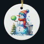 Heb de Merriest Christmas by Par | Schijfgolf Keramisch Ornament<br><div class="desc">Heb de leukste Kerstmis door par. Disc golf thema kunst. Schattigee waterverf cartoon sneeuwpop in Santa hat naast een disc golfmand in de sneeuw naast een kerstboom.</div>