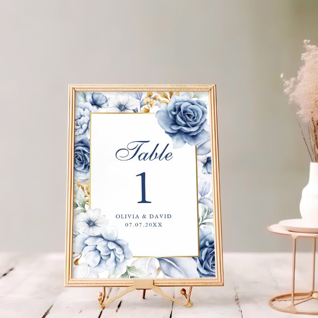 Hedendaags Blauw en Goud Bloem Tafelnummer voor Tr (Modern Blue and Gold Floral Wedding Table Number on a rustic white wooden table next to flowers)