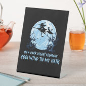 Heksen spelen op een donkere woestijnweg reclamebord met voetstuk (Insitu)