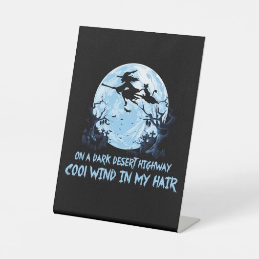 Heksen spelen op een donkere woestijnweg reclamebord met voetstuk (Voorkant)