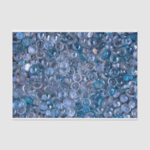 Helder en blauw gekleurde glazen knikkers in water tissuepapier