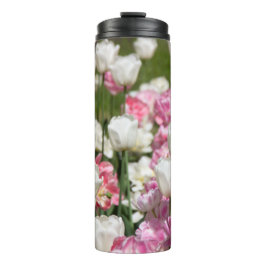 Helder witte en roze tulpen op een zonnige thermosbeker