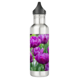 Heldere lila tulpen op een zonnige dag waterfles 