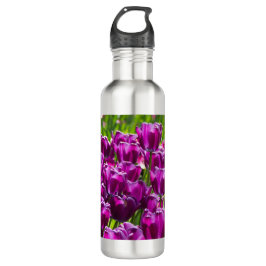 Heldere lila tulpen op een zonnige dag waterfles 