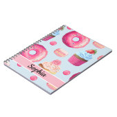 Heldere roze noten en koekjes op babyblauw notitieboek (Linkerzijde)