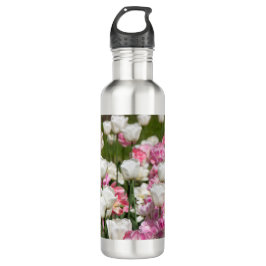 Heldere witte en roze tulpen op een zonnige waterfles 