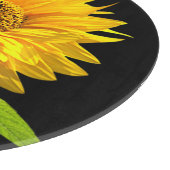 Heldere zonnebloem op zwarte achtergrond snijplank (Hoek)