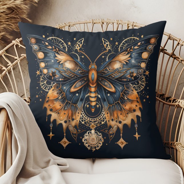 Hemelse Mot - Gouden Maan Worp Kussen (Celestial Moth – Golden Moon Throw Pillow in a boho rattan armchair.)