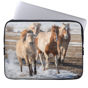 Herd van gemengde fokpaarden die in de sneeuw lope laptop sleeve