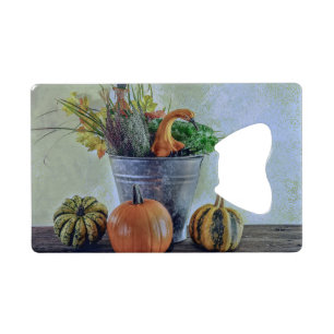 Herfst stilleven met pompoenen, bloemen creditkaart flessenopener