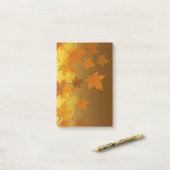 Herfstpatroon met vallende esdoornbladeren en boke post-it® notes (Op bureau)
