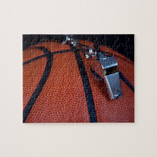 Het fluitje van een scheidsrechter ligt bovenop ee legpuzzel (Horizontaal)