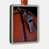 Het fluitje van een scheidsrechter ligt bovenop ee metalen ornament (Rechts)