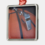 Het fluitje van een scheidsrechter ligt bovenop ee metalen ornament (Links)