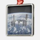 Het internationale ruimtestation in een baan om de metalen ornament (Links)