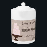 Het leven is kort, zodat je de mond kunt snoeren theepot<br><div class="desc">Slogan "Het leven is zo kort dat je taart,  heel veel taart" hebt met roze gevriesde gebak op een opstand met een hartenachtergrond. Kleine theepot.</div>