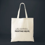 Het schilderen helpt grappig om kunstenaars aan te tote bag<br><div class="desc">In deze tas staat de tekst "LIFE HAPPENS...  | PAINTING HELPS" in zwarte tekst. Perfect terug om breien,  garen of wat dan ook mee te nemen. Elke lijn van tekst kan worden gepersonaliseerd.</div>