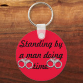 Het staan door een man die tijd sleutelhanger doet (Voorkant)